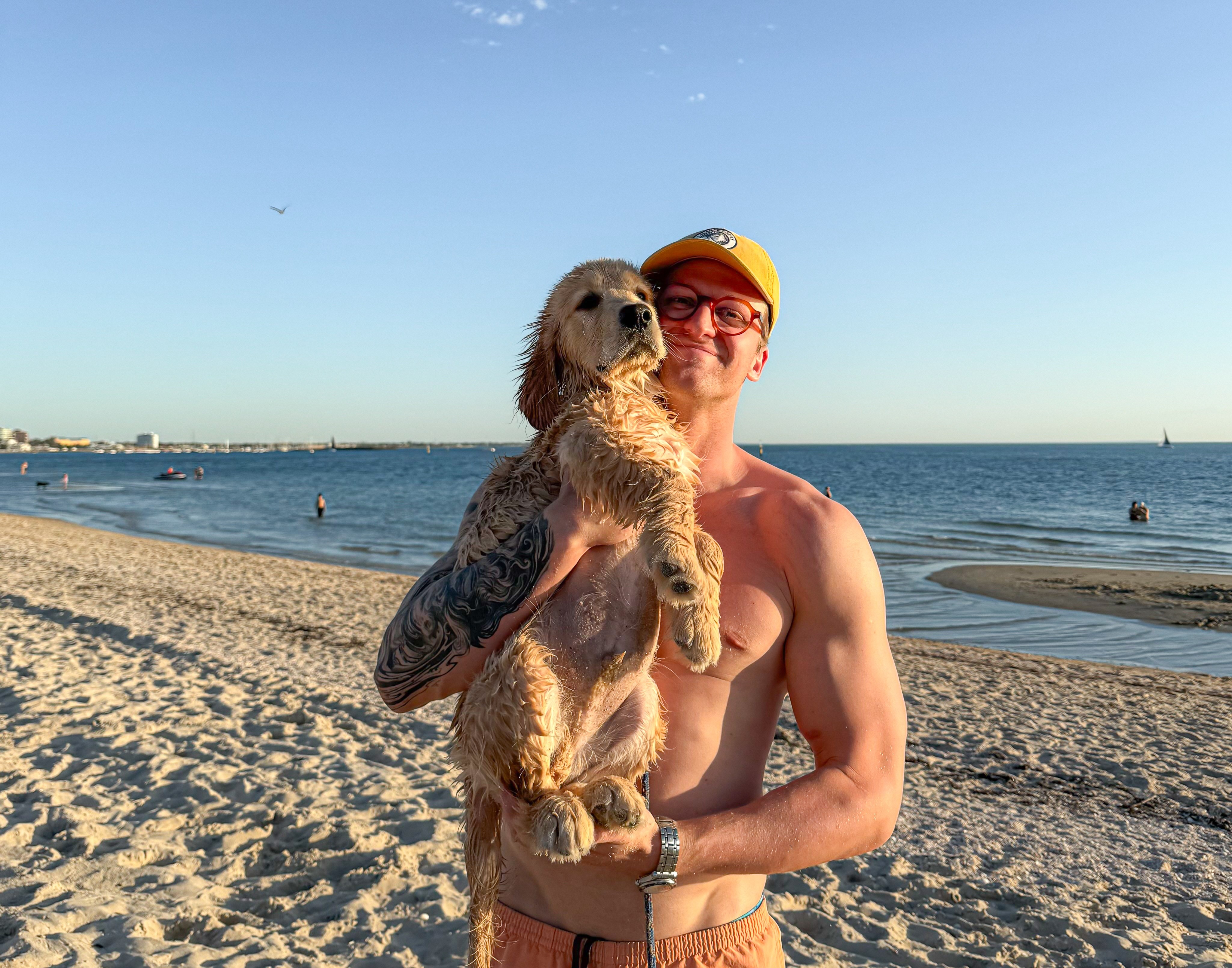 Sam Williamson carries his dog, a golden retriever on his shoulder.