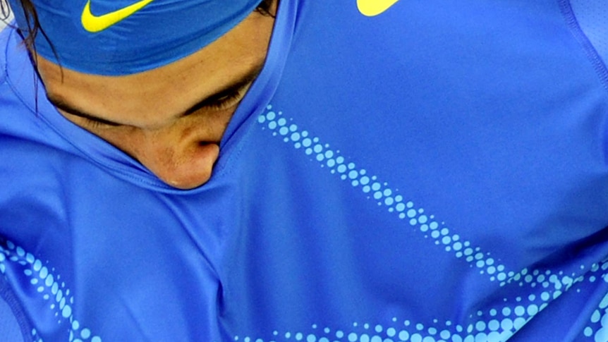 Rafael Nadal's face pokes through as he changes his shirt at the US Open