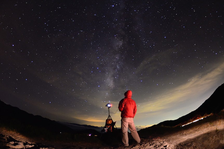 A photographer looks out at the night sky