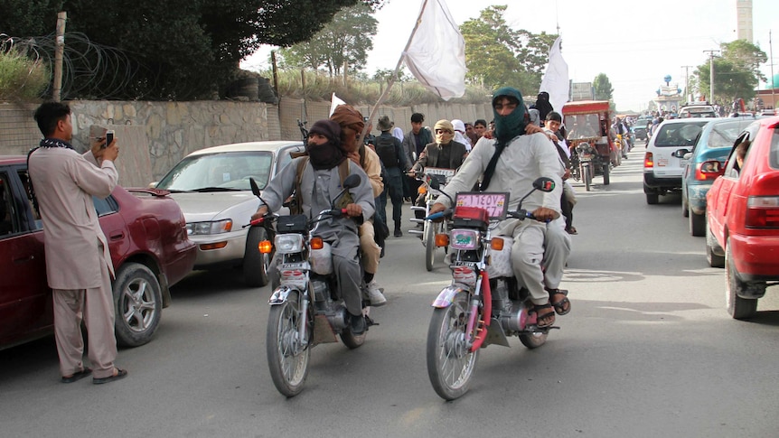 Taliban fighters ride their motorbikes inside Ghazni city