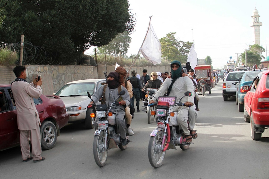 Taliban fighters ride their motorbikes inside Ghazni city