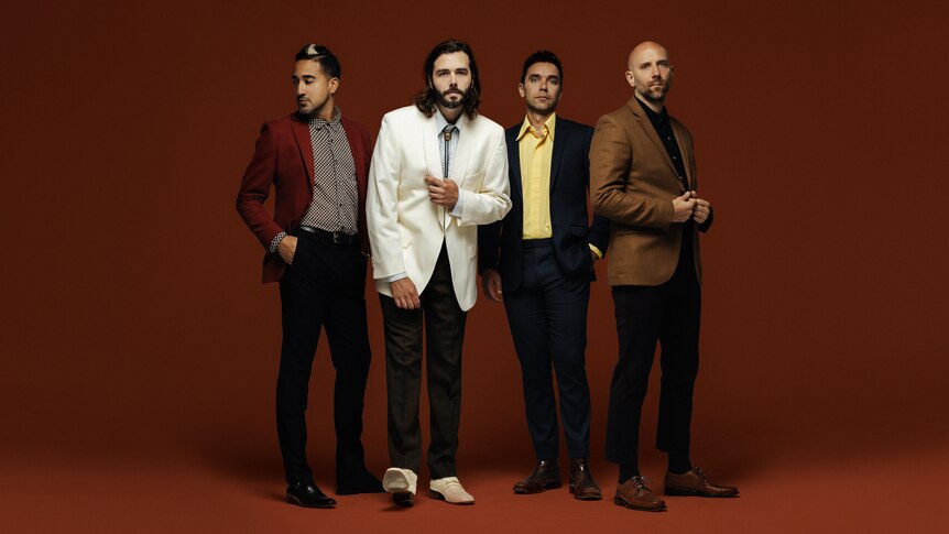 A press shot of Lord Huron's four band members on a red/brown soundstage