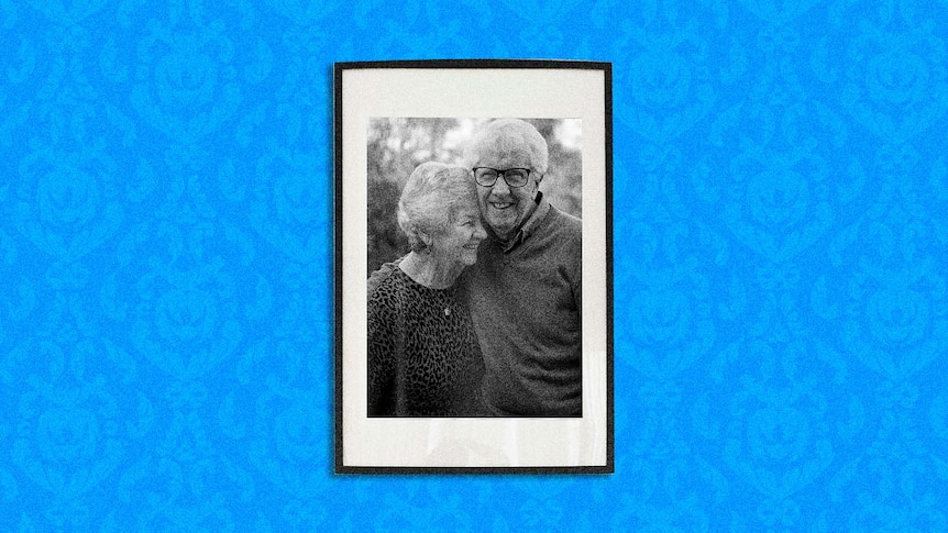 blue background with pattern and photo of an elderly couple smiling and hugging each other.