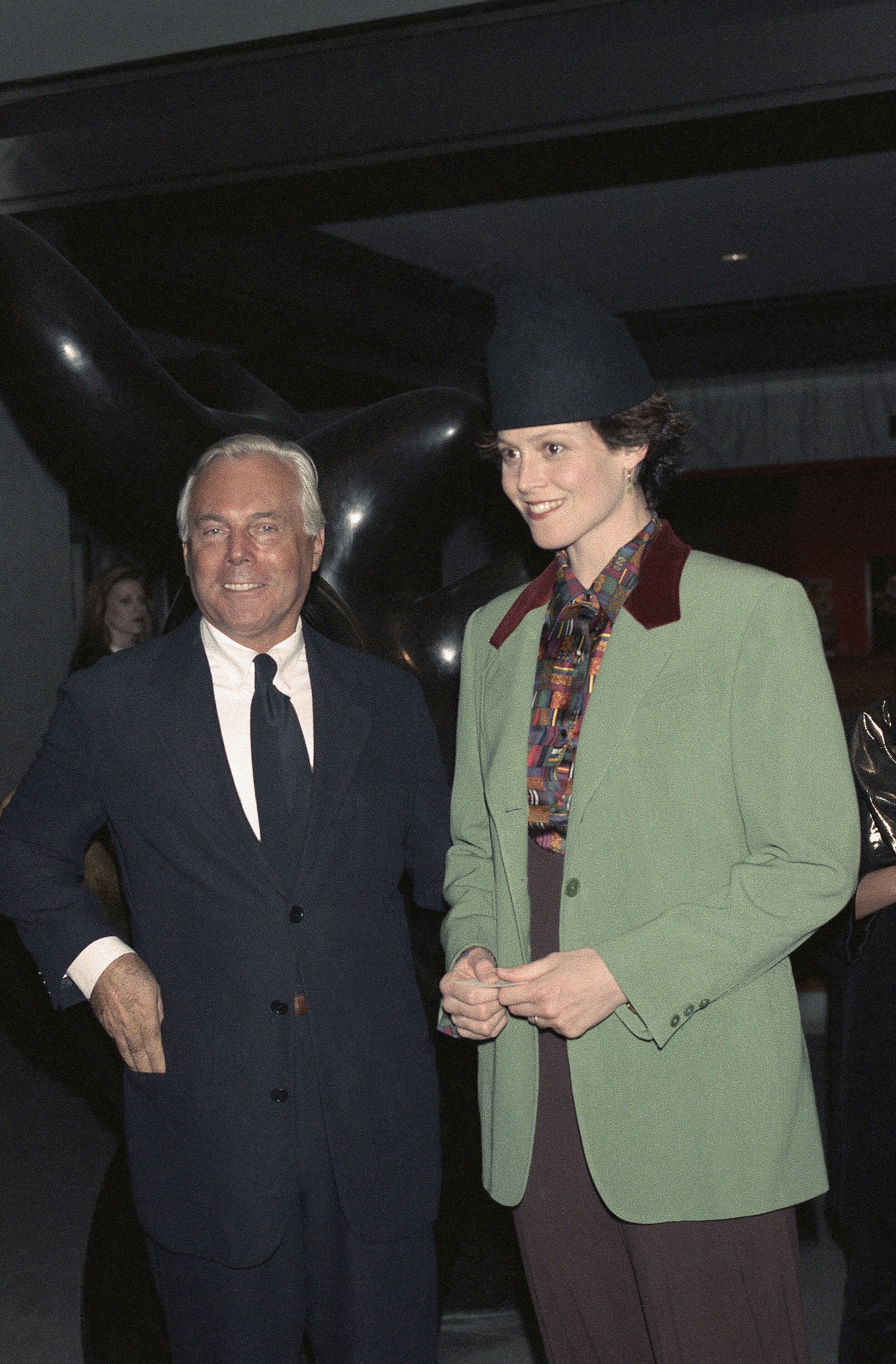 Giorgio Armani smiling next to  Sigourney Weaver. 