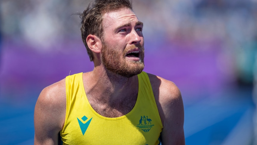 Ollie Hoare looks emotional while wearing an Australian running kit