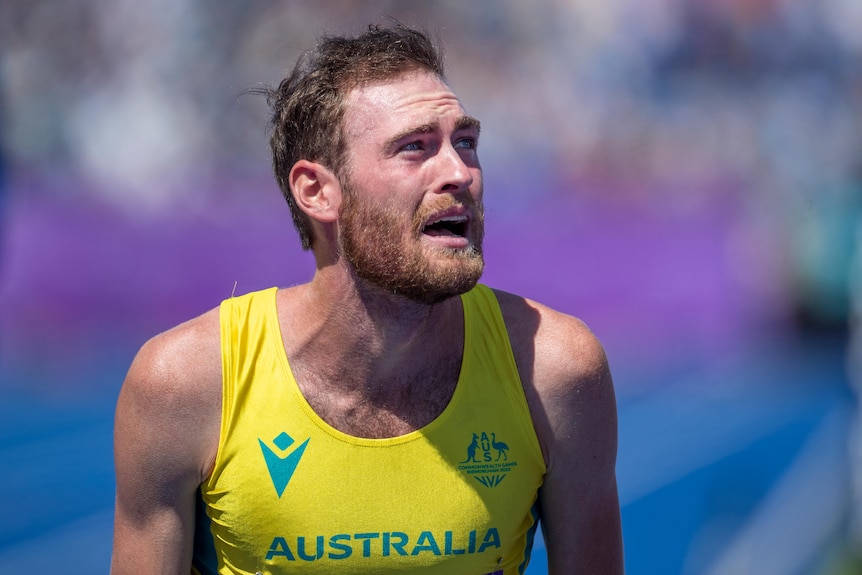 Ollie Hoare looks emotional while wearing an Australian running kit