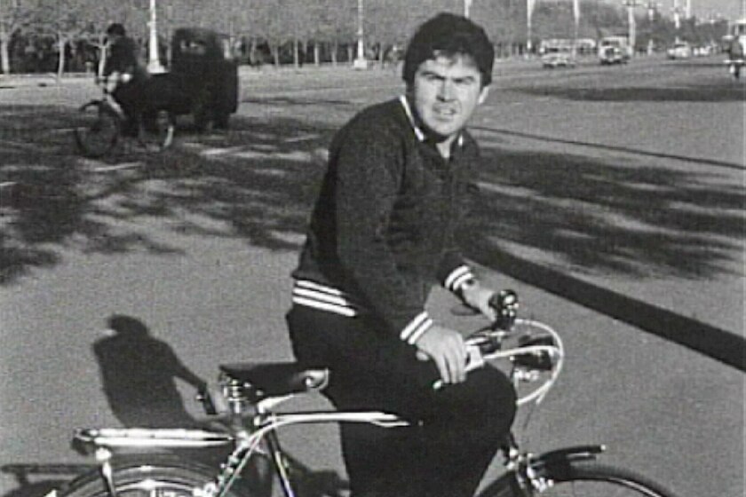 Paul Raffaele rides a bike on a street in Peking in 1973.