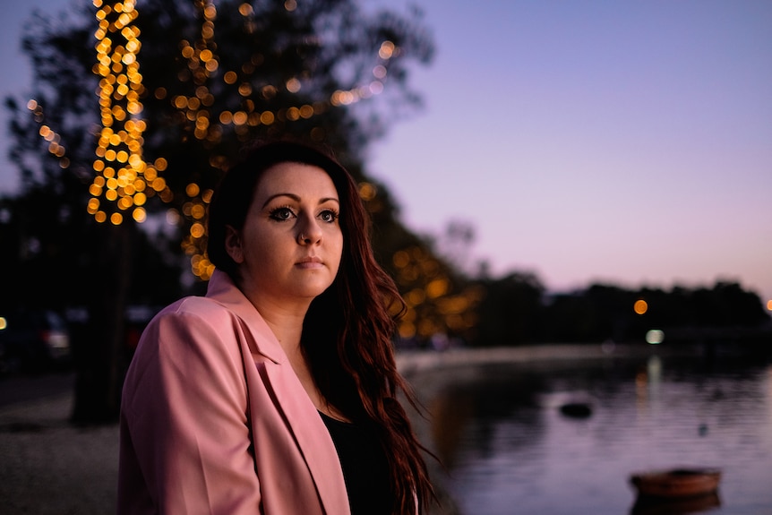 Tamara Georgopoulos looks into the distance sitting near water.