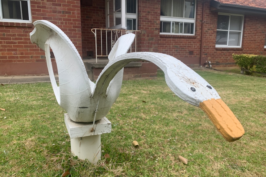 An image of a white swan made from car tyres in a front yard