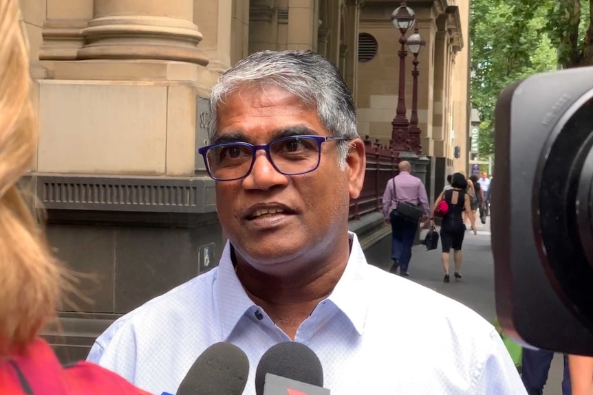 A man stands outside court talking to the media