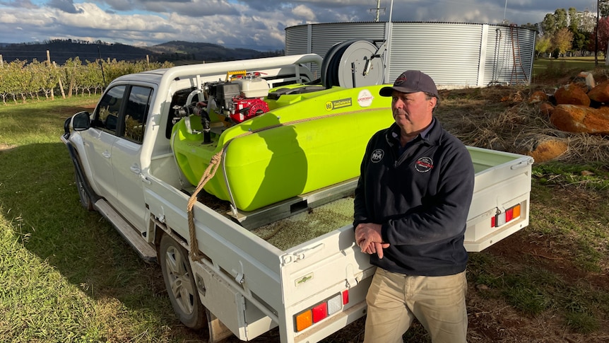 Ian Cathels standing next to ute with mobile firefighting equipment and water tank.