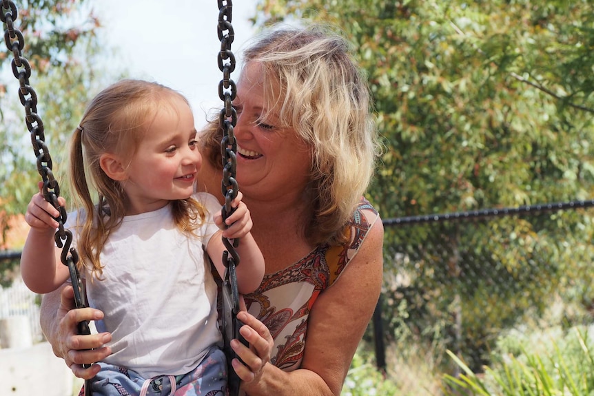 Kath Leane holds the swing for her granddaughter.