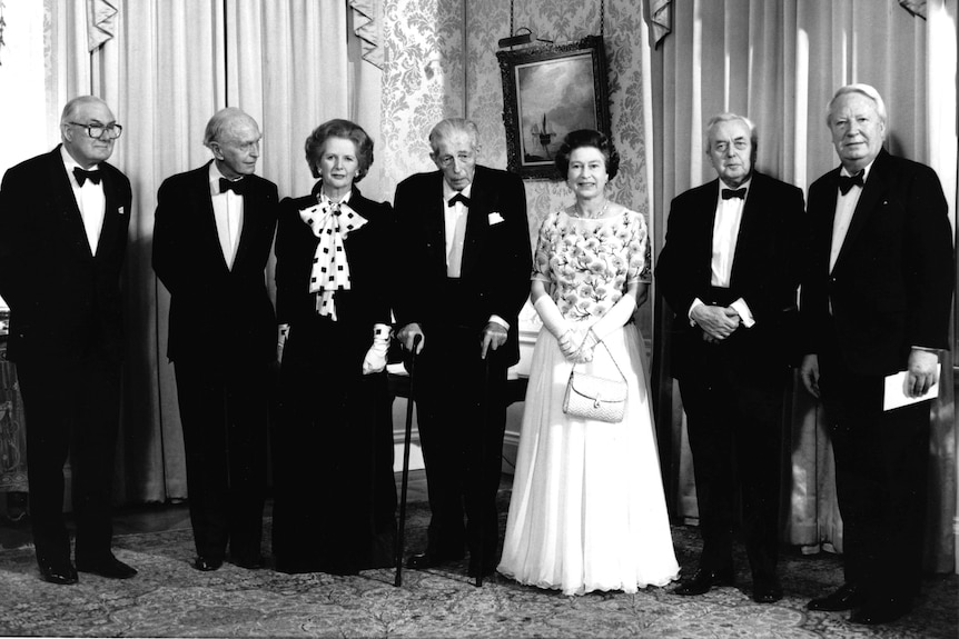 Queen Elizabeth II stands in the centre of UK Prime Ministers past and present.