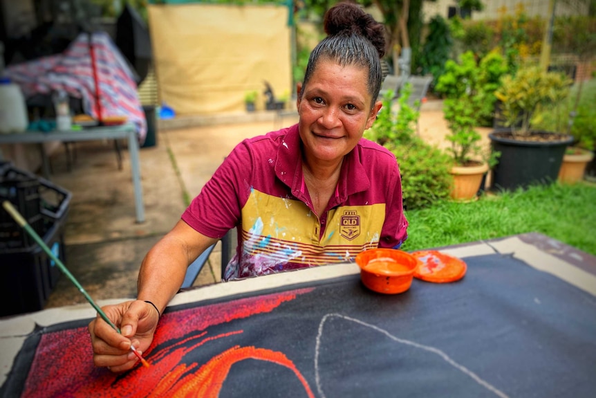 A woman does a dot painting