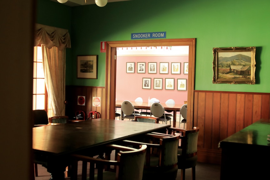 Two empty rooms with a view through to a large dining area with 'snooker room' written above the doorway.