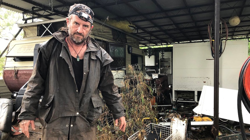 Resident Steve Sinclair stands among his flood-damaged property at Bluewater, near Townsville in north Queensland.