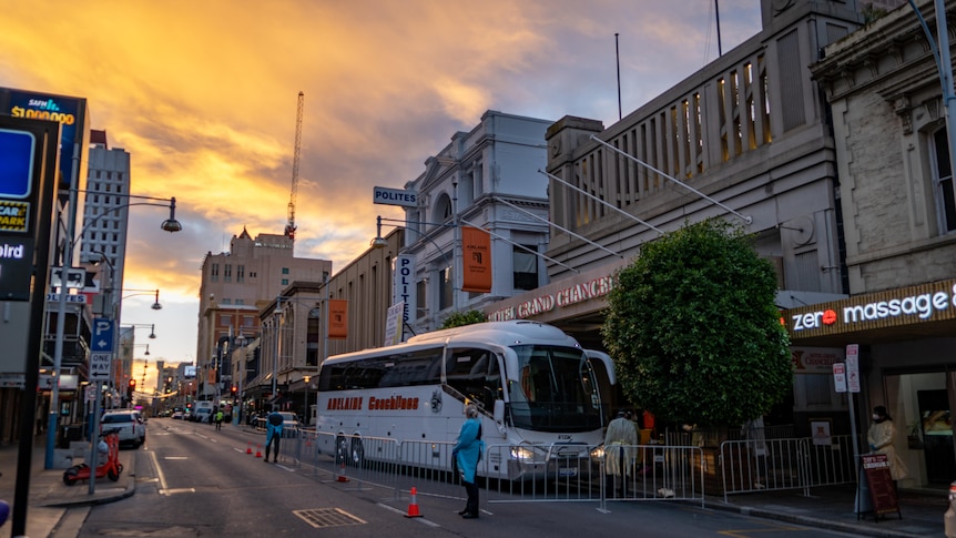 A hotel building in Adelaide's CBD with a bus parked in front of it