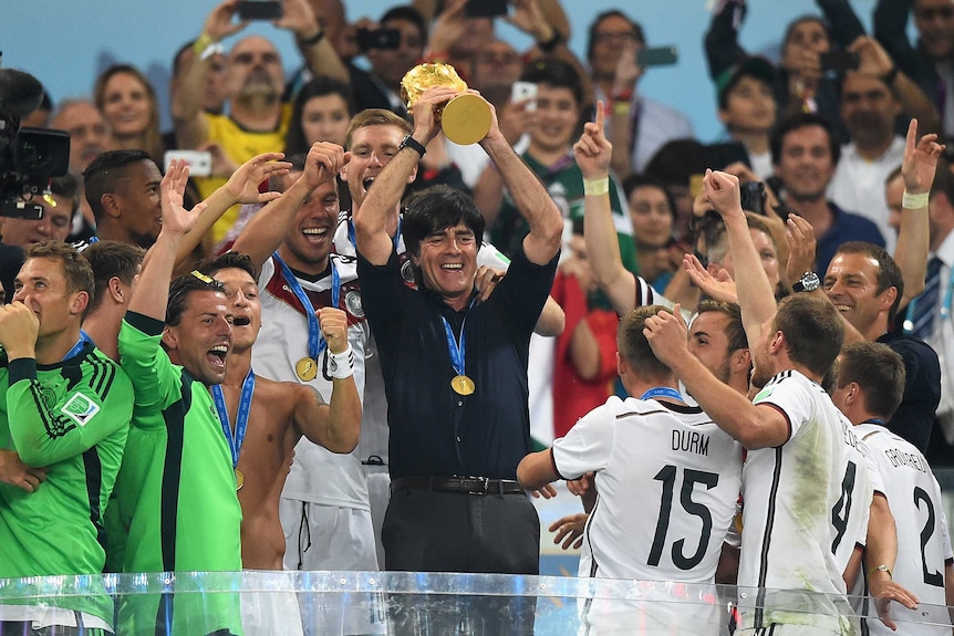 Joachim Loew celebrates with World Cup trophy