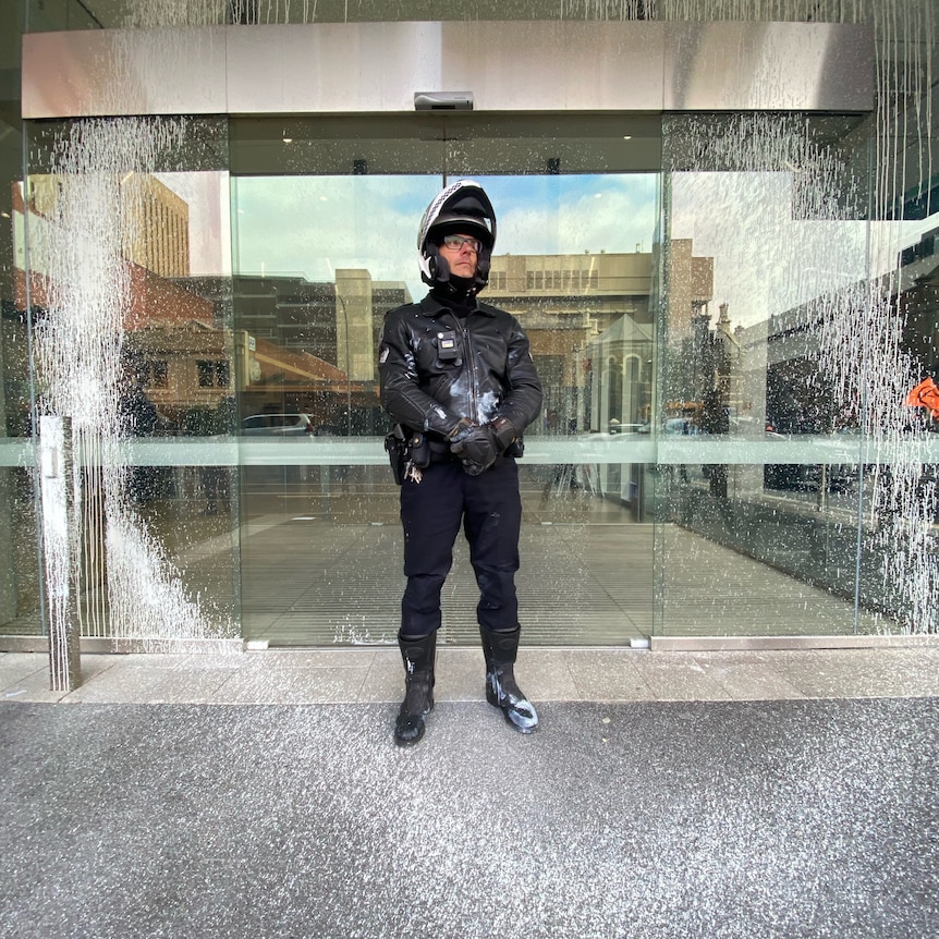 A police officer covered in paint 