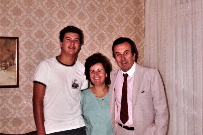 A 1970s photograph of a young man with his parents in a lounge room