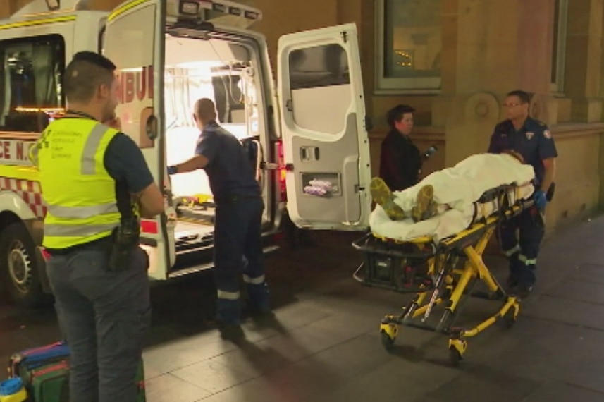 A man on a stretcher, being put into an ambulance