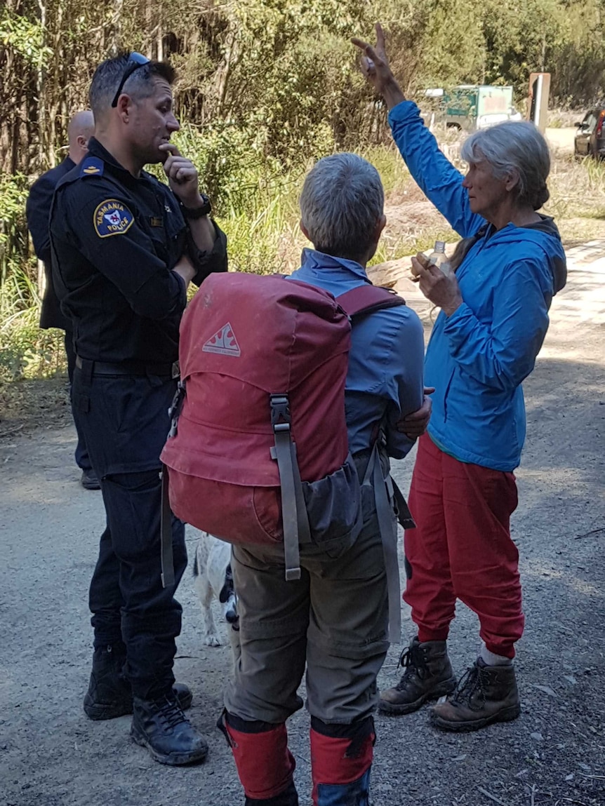 The wife of the missing bushwalker, right, talks with police