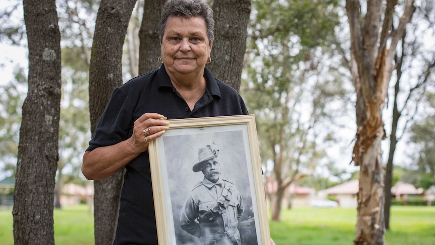 An Aboriginal Elder holds a photo of her grandfather Private Augustus Hodgkinson Davies.