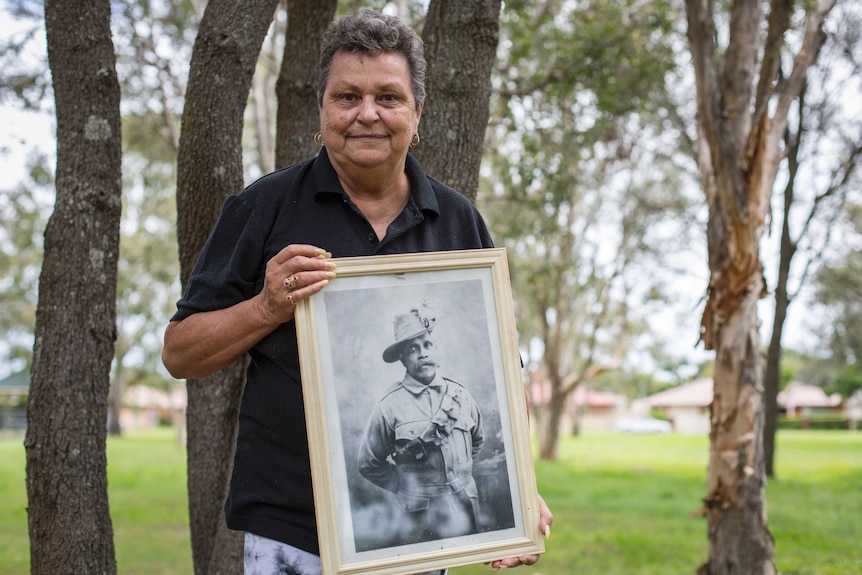 An Aboriginal Elder holds a photo of her grandfather Private Augustus Hodgkinson Davies.