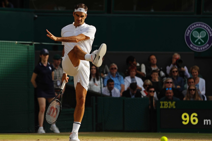 Roger Federer kicks at a tennis ball during his Wimbledon semi-final at Tomas Berdych.