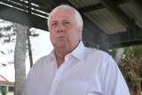 Clive Palmer with white shirt and white hair, rain drops on camera lens