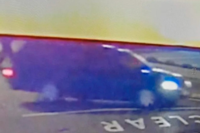 A blurry CCTV still if a black station wagon.