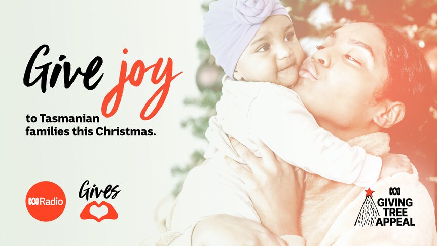 A woman holds up a baby, kissing them on the cheek. Text to the left reads "Give joy to Tasmanian families this Christmas".