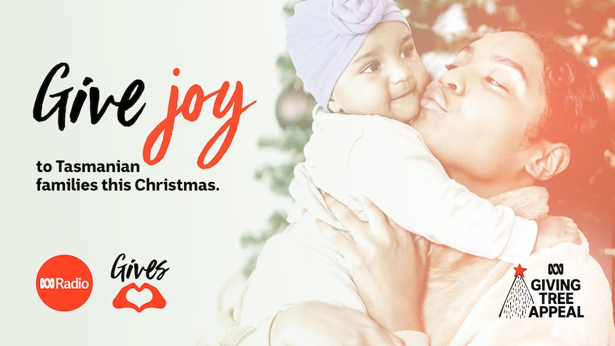 A woman holds up a baby, kissing them on the cheek. Text to the left reads "Give joy to Tasmanian families this Christmas".