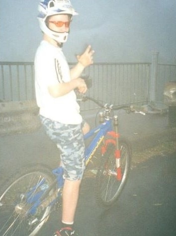 Young man wearing a helmet poses on a mountain bike.