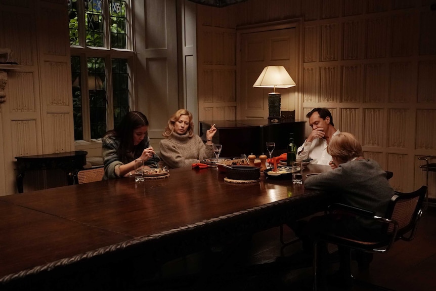 A family sit around a long and imposing dinner table in the film The Nest