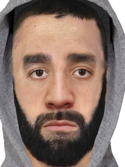 A man with dark eyebrows, dark beard wearing a grey hoodie 