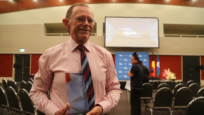 Dr Geoffrey Thompson holds his award for NT Australian of the Year