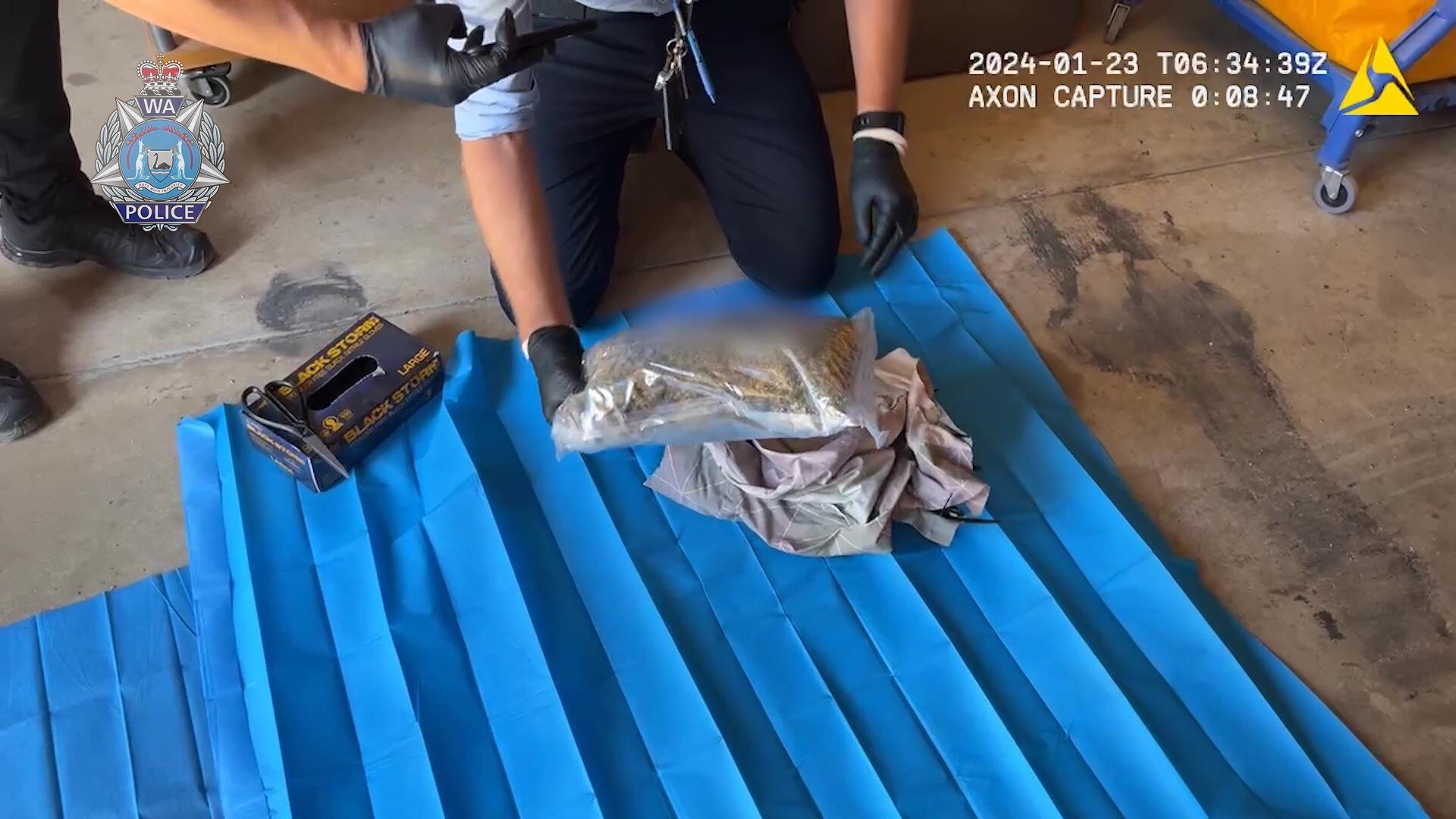 Police officer uncovers plastic bag of substance alleged to be drugs. 