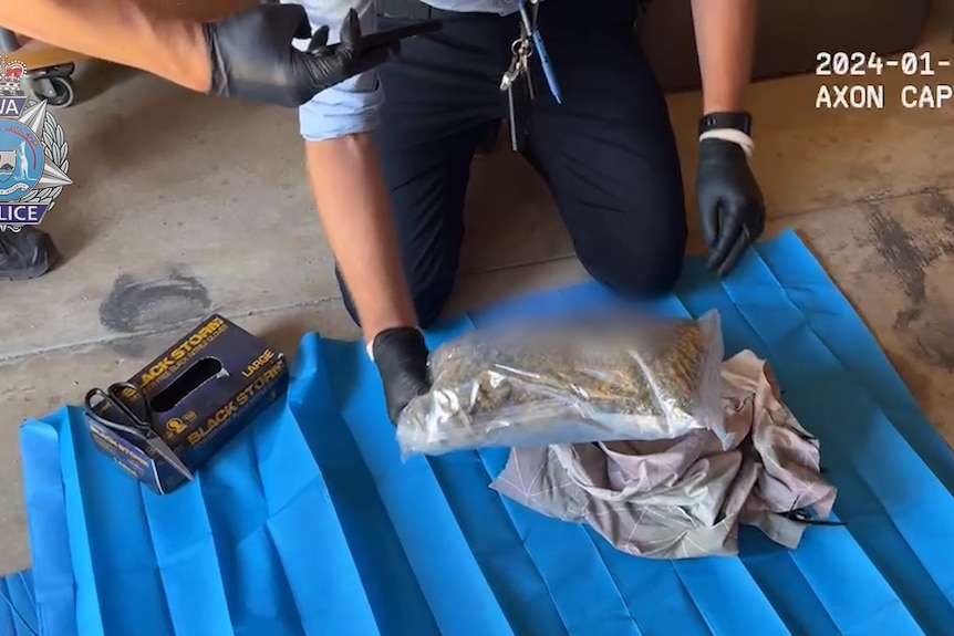 Police officer uncovers plastic bag of substance alleged to be drugs. 