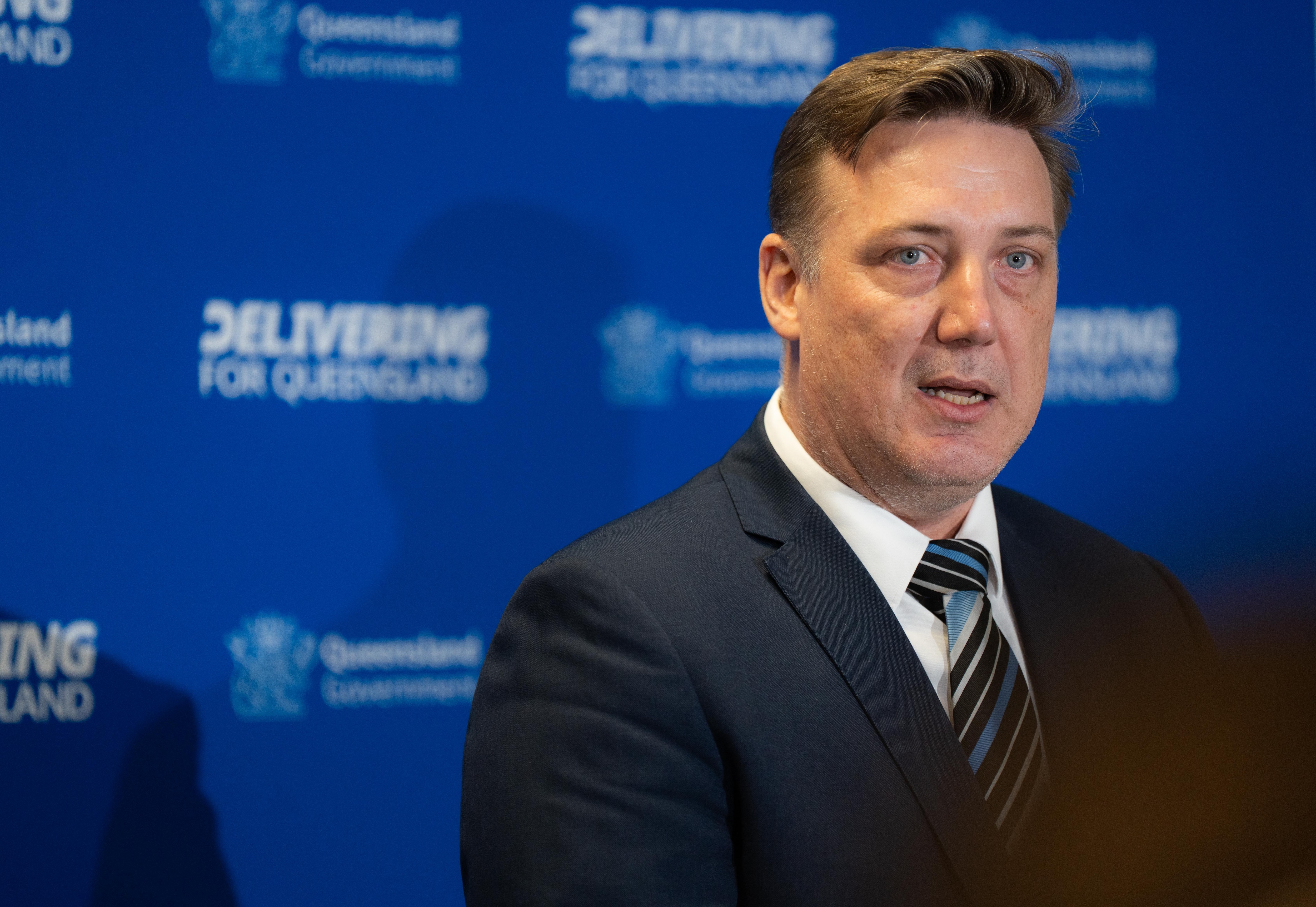 A man in a suit speaking to media.