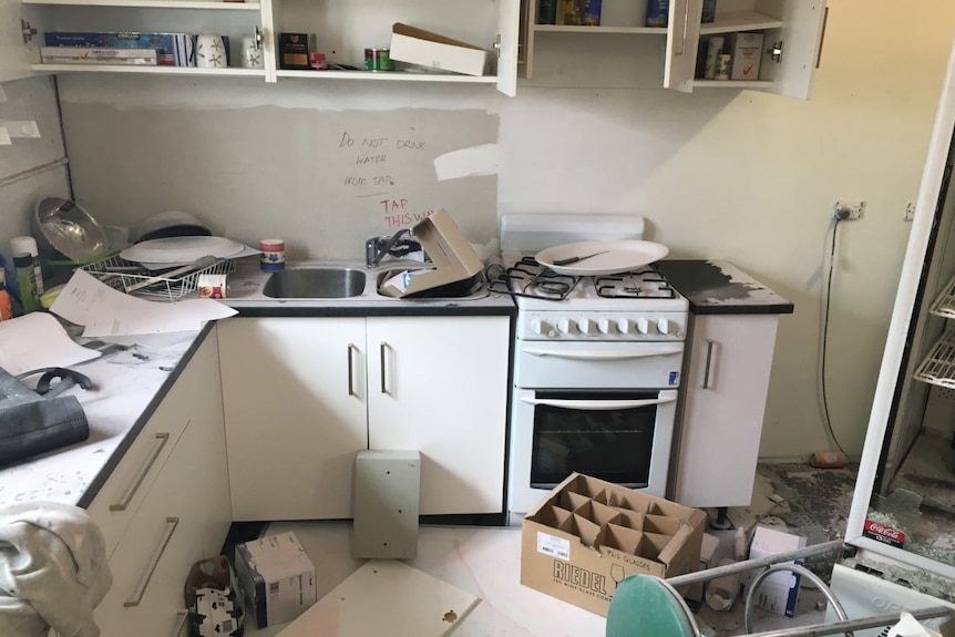 A kitchen area in a community building in serious disarray.