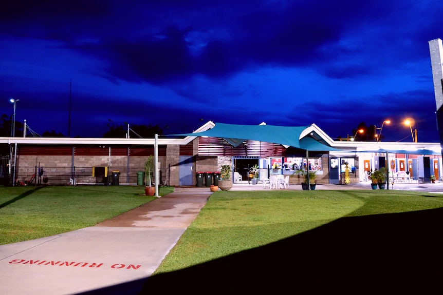 a stormy evening sky looms over the warm lights of the dysart swim centre