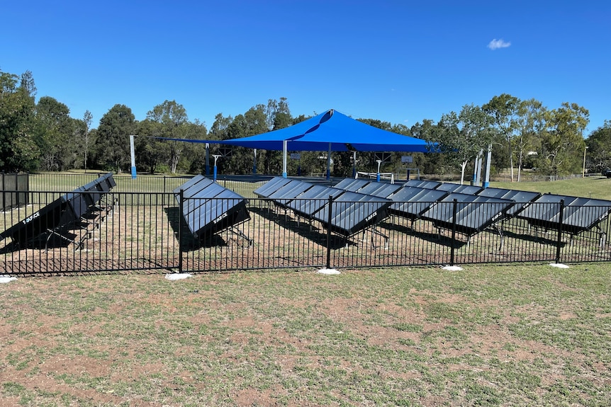 An array of panels, similar to solar panels, laid out in a school grass area.