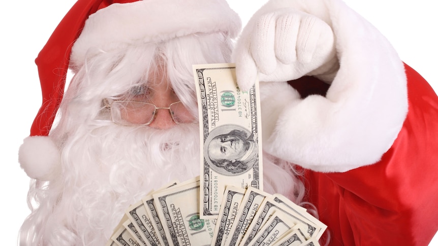 Santa Claus holding dollar money (Thinkstock:  iStockphoto)