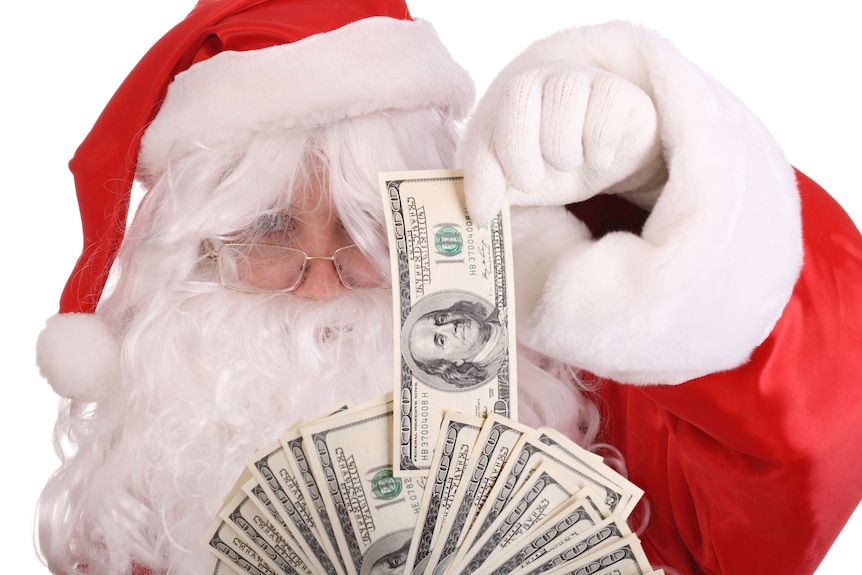 Santa Claus holding dollar money (Thinkstock:  iStockphoto)