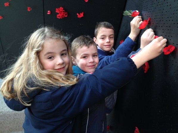 Children place poppies at the Shrine