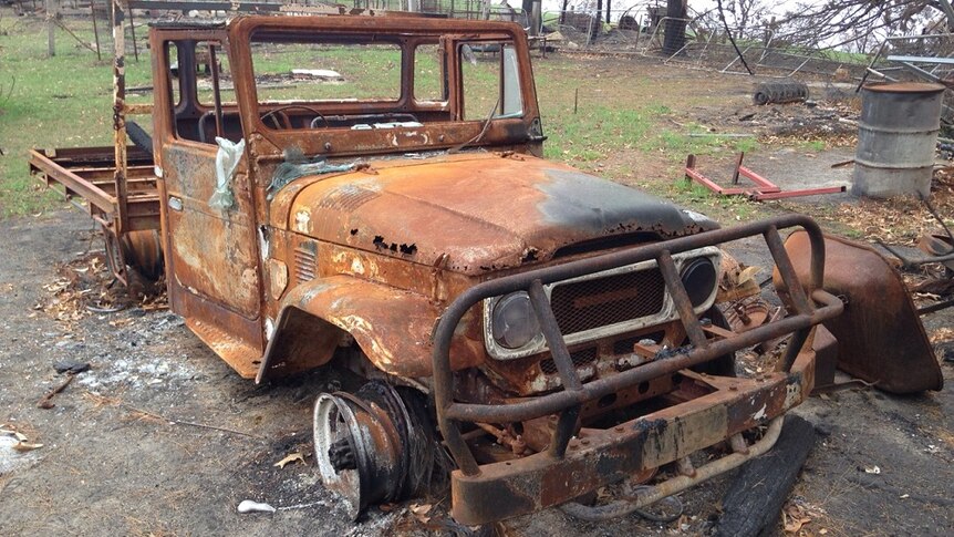 A burnt out ute on a farm property.