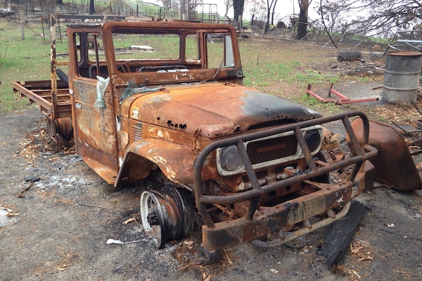 A burnt out ute on a farm property.