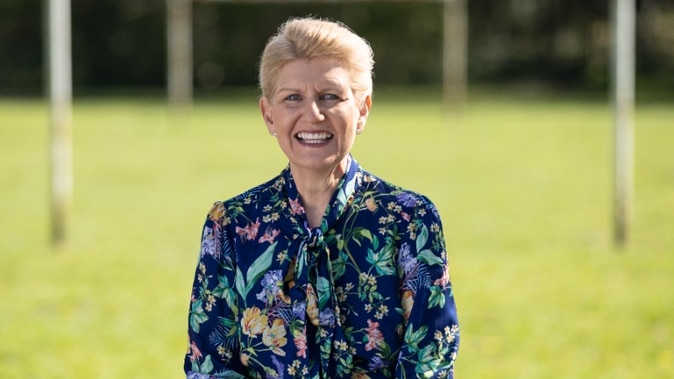 A British female sitting while being photographed.