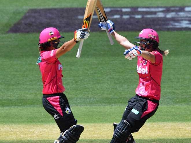 Ashleigh Gardner and Ellyse Perry raise their bats in the air as they celebrate.
